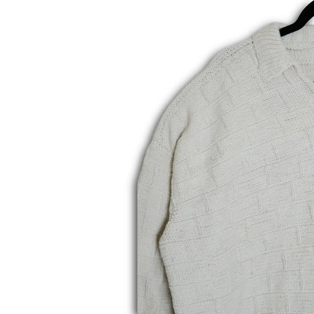 Light gray textured sweater on a hanger against a white background