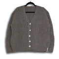 Gray cardigan on a hanger against a white background