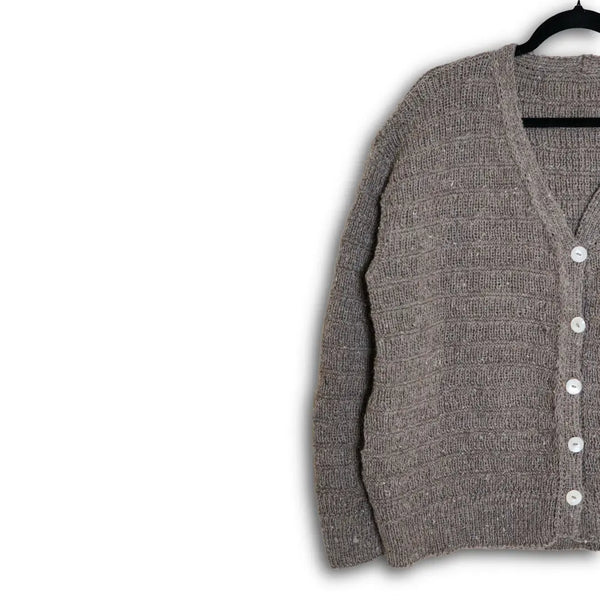 Gray cardigan with button details on a hanger against a white background