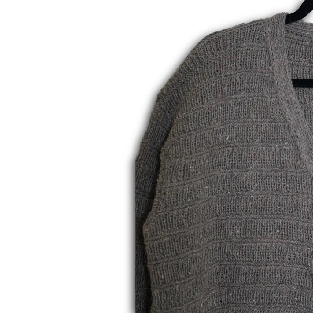 Gray textured sweater on a hanger against a white background