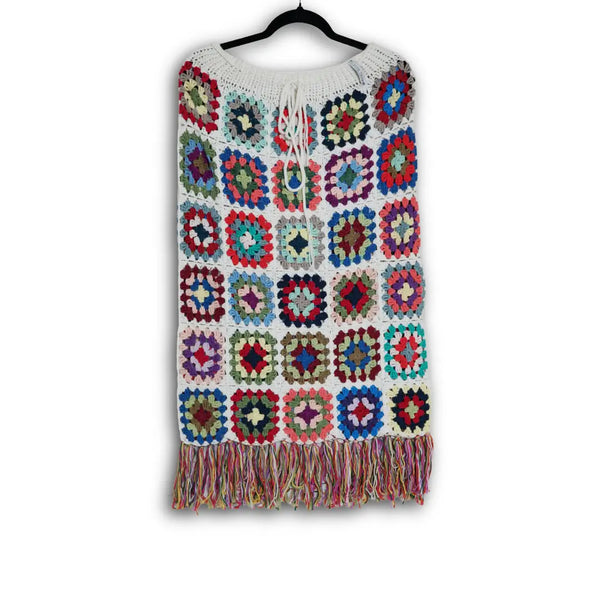 Colorful crochet skirt with square patterns on a hanger against a white background