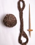 Handspun 100% pure Himalayan brown wool yarn ball and traditional spindle from Lahaul Valley artisans for sustainable fashion brands.
